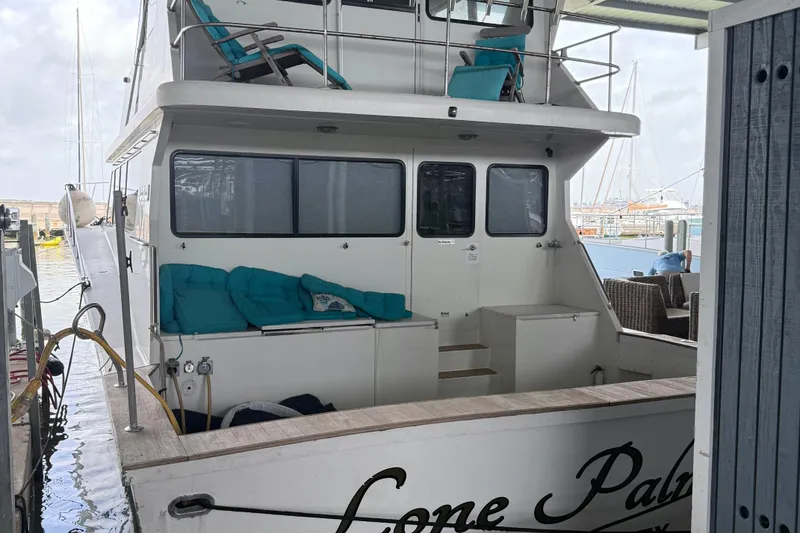 Slide: The Image of 2001 Darling Yachts 62 Enclosed Bridge docked, featuring outdoor seating and upper deck. - 2