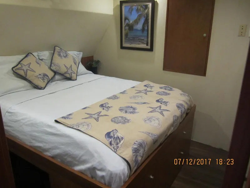 Slide: The Image of Cozy bedroom in 2001 Darling Yachts 62 Enclosed Bridge, featuring nautical-themed decor. - 9