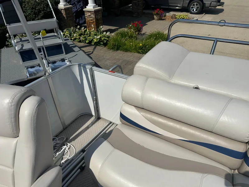 Slide: The Image of 2006 Crest Caribbean 250 boat interior with white seating and outdoor background. - 12