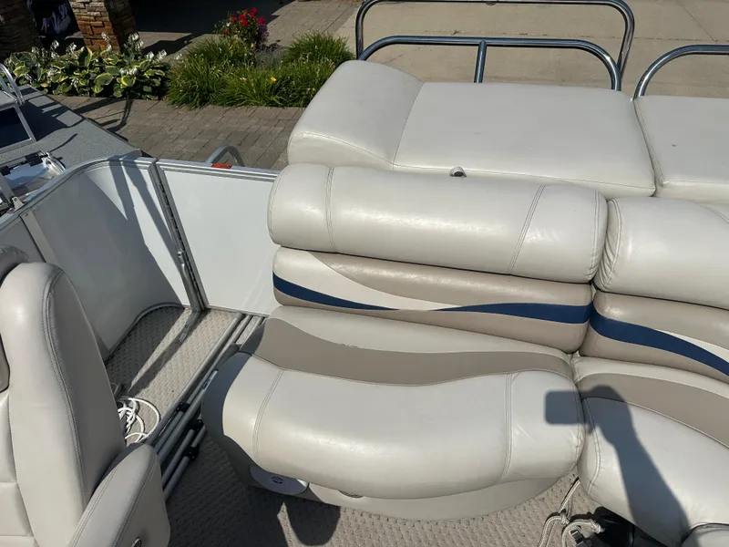 Slide: The Image of 2006 Crest Caribbean 250 boat interior with white and beige seating, outdoor setting. - 13