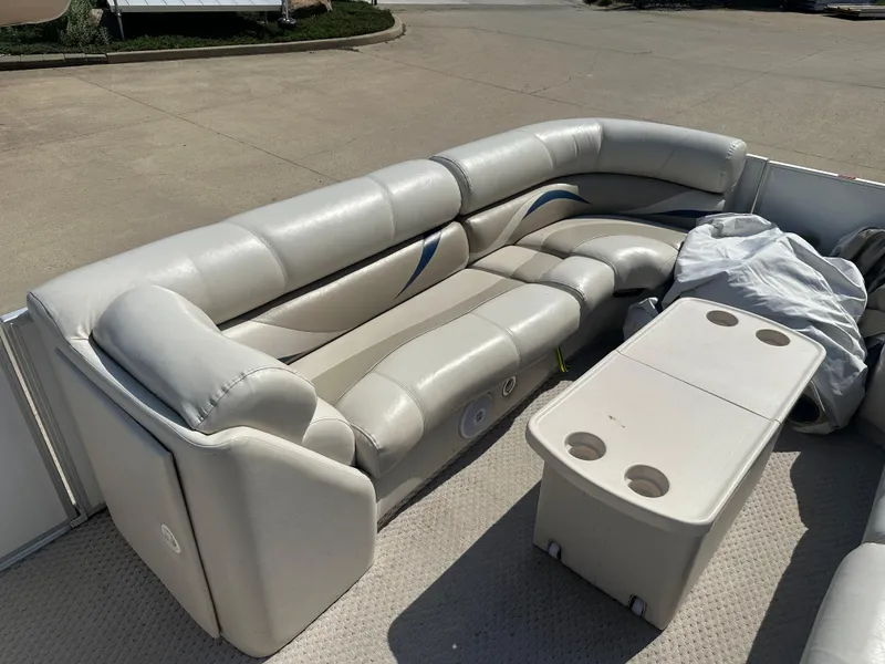Slide: The Image of 2006 Crest Caribbean 250 boat interior with beige seating and a table with cup holders. - 16