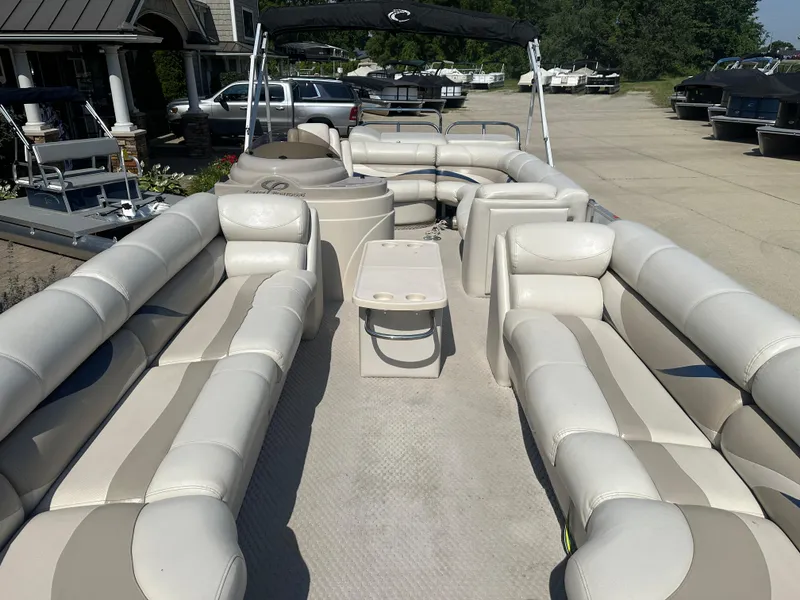 Slide: The Image of 2006 Crest Caribbean 250 pontoon boat with spacious seating and table, docked outdoors. - 3