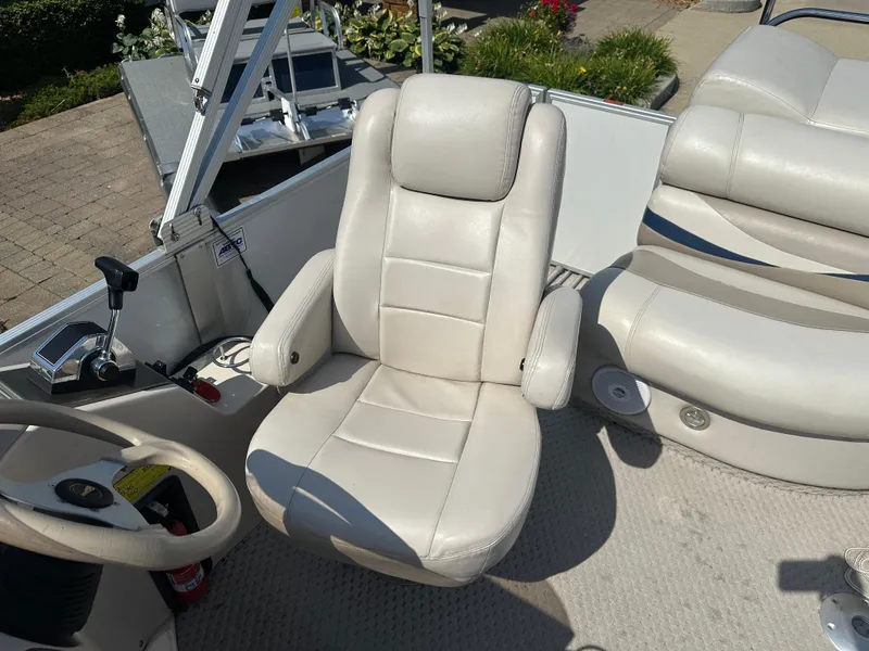 Slide: The Image of Captain's chair on 2006 Crest Caribbean 250 boat, featuring beige upholstery and control panel. - 8