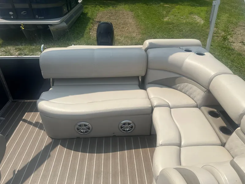 Slide: The Image of 2017 Harris Sunliner 230 pontoon boat with beige seating and cup holders on deck. - 11