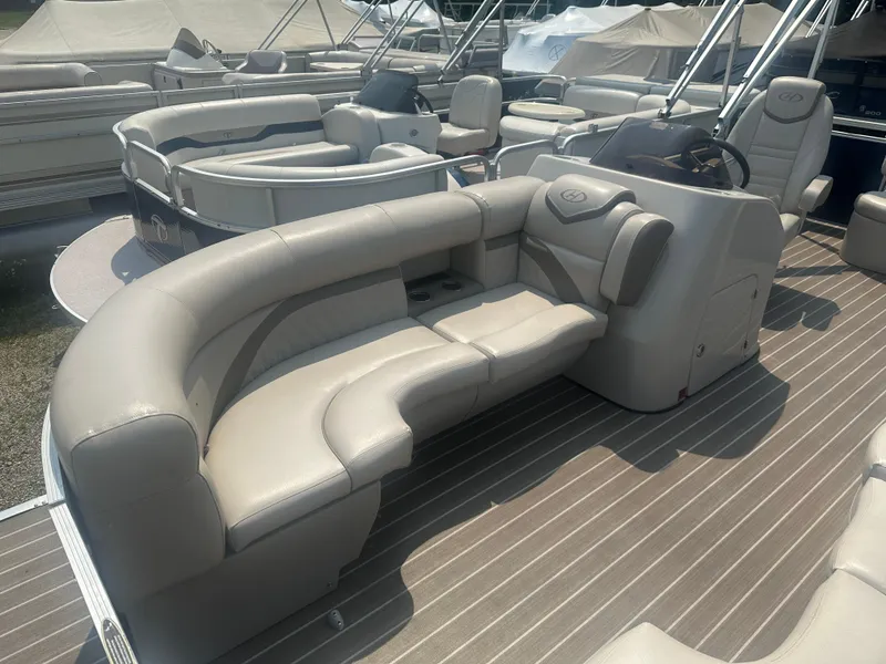Slide: The Image of 2017 Harris Sunliner 230 pontoon boat with beige seating and steering console. - 6