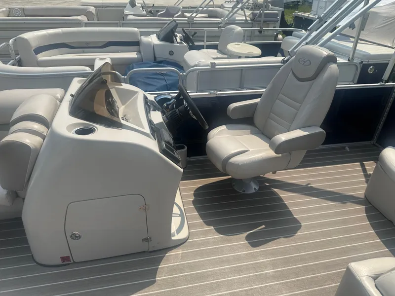 Slide: The Image of 2017 Harris Sunliner 230 boat interior with captain's chair and helm. - 7