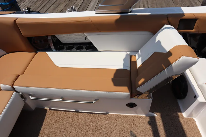 Slide: The Image of 2020 MasterCraft X24 boat interior with tan and white seating, cup holders, and adjustable backrest. - 11