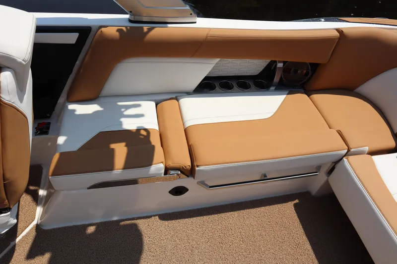 Slide: The Image of 2020 MasterCraft X24 boat interior with tan and white seating, cup holders, and sleek design. - 13