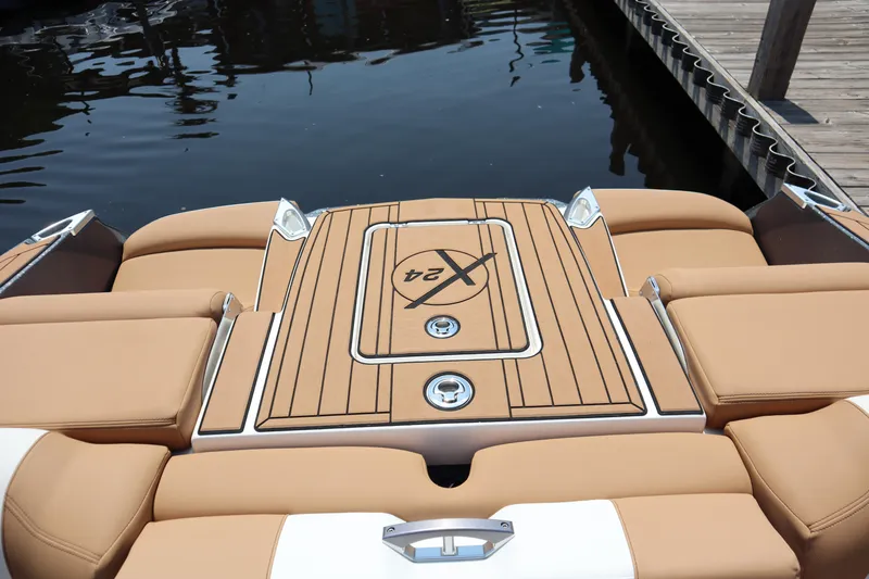 Slide: The Image of 2020 MasterCraft X24 boat with tan seating and sleek deck design at a dock. - 16