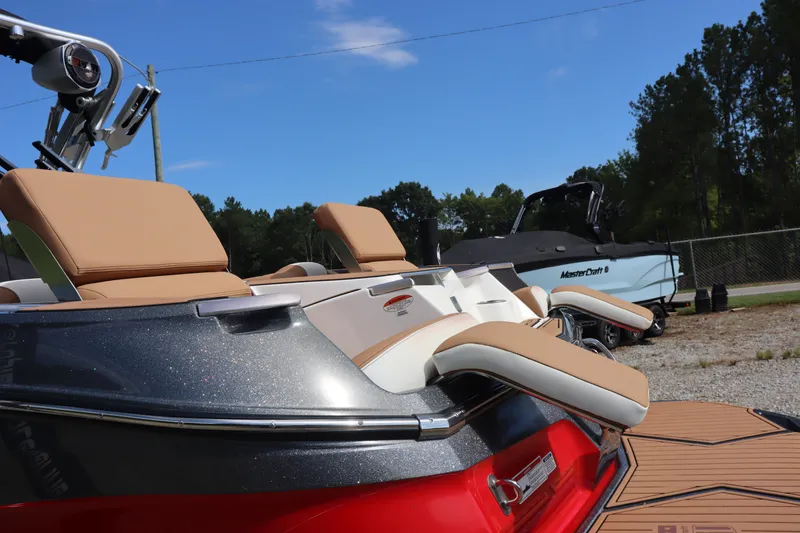 Slide: The Image of 2020 MasterCraft X24 boat with tan seats and sleek design, parked outdoors. - 19