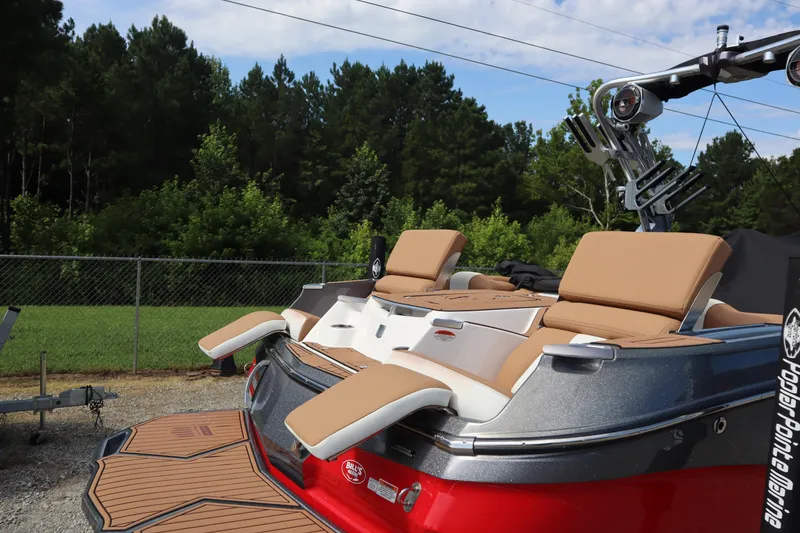 Slide: The Image of 2020 MasterCraft X24 boat with tan seating and sleek design, parked outdoors. - 20