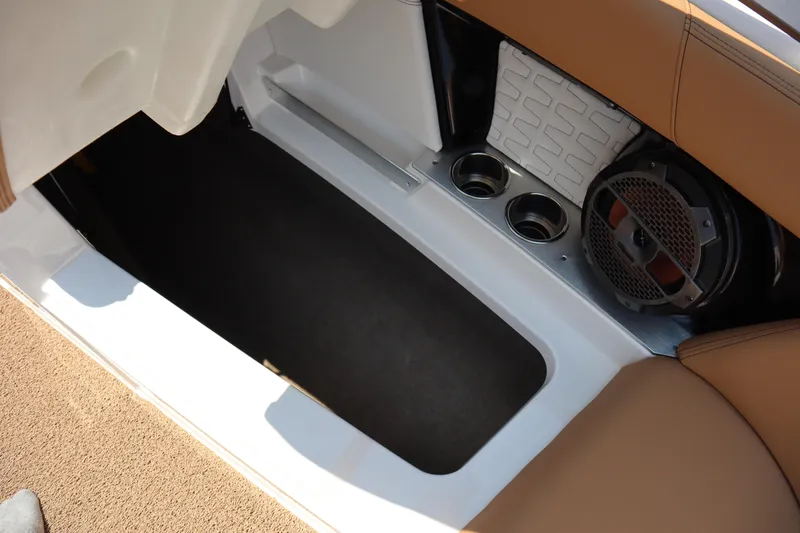 Slide: The Image of 2020 MasterCraft X24 boat interior storage compartment with cup holders and speaker. - 6
