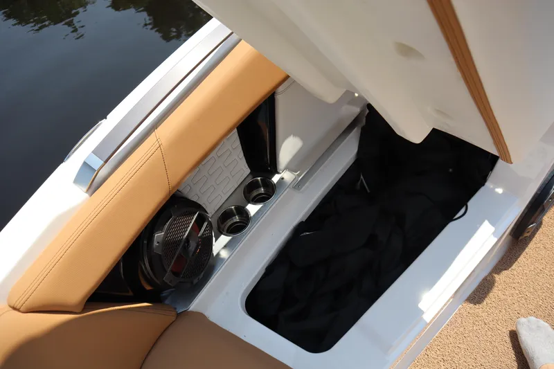Slide: The Image of 2020 MasterCraft X24 boat storage compartment with cup holders and speaker. - 7