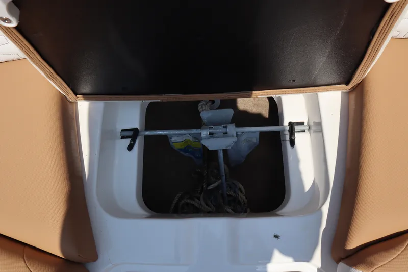 Slide: The Image of 2020 MasterCraft X24 boat anchor storage compartment with tan seating. - 8
