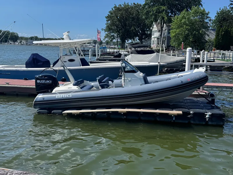 Slide: The Image of 2022 Brig Eagle 6 boat docked with Suzuki engine, scenic waterfront background. - 32