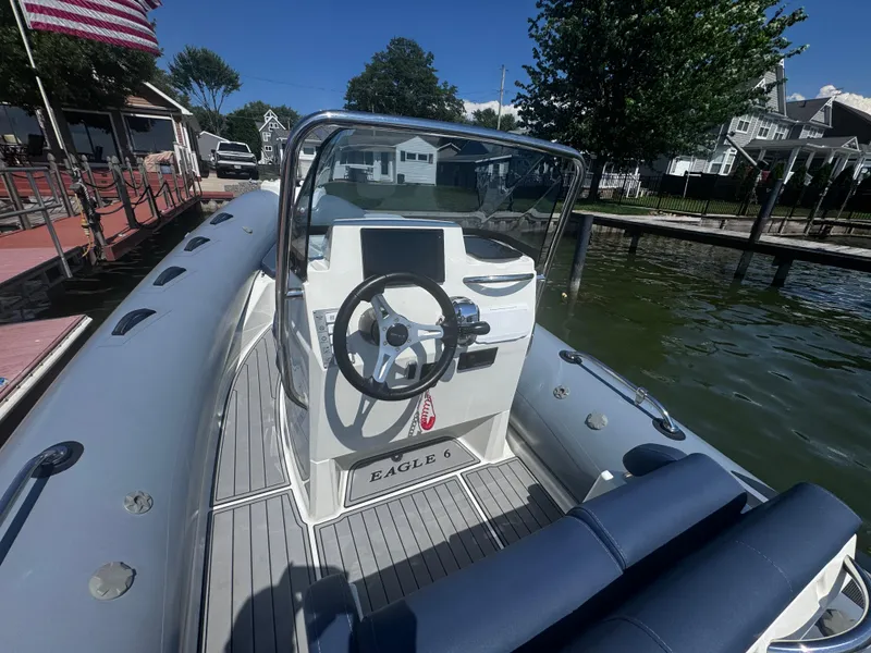 Slide: The Image of 2022 Brig Eagle 6 boat with steering wheel, docked by a lakeside. - 9