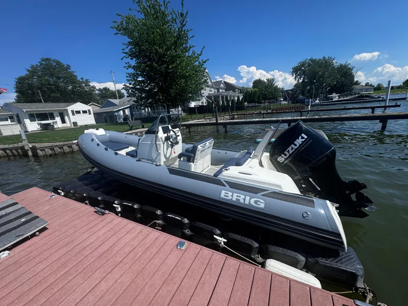 Slide: The Image of 2022 Brig Eagle 6 boat docked by a lakeside with Suzuki outboard motor. - 4