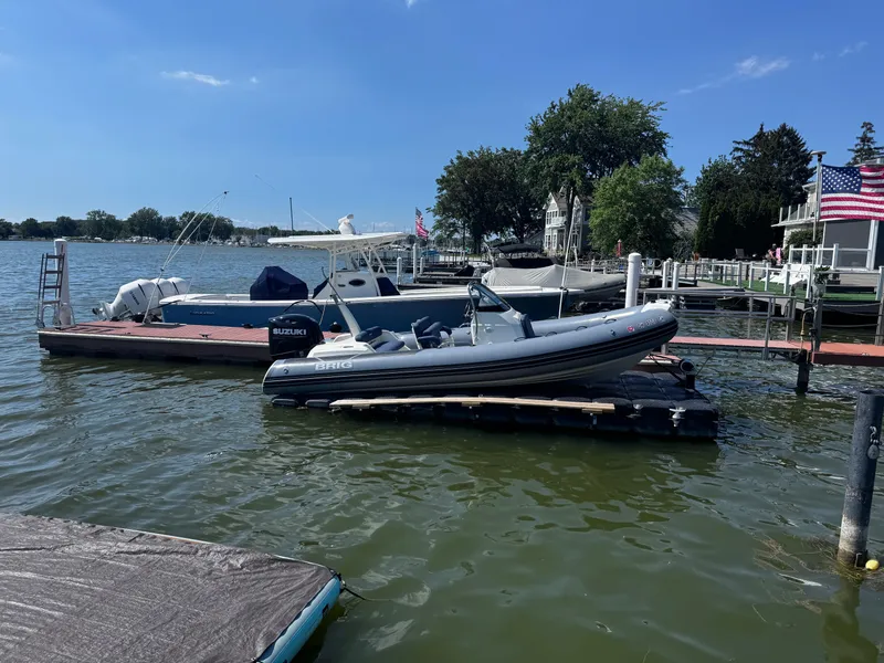 Slide: The Image of 2022 Brig Eagle 6 boat docked on a sunny day, with American flag in background. - 31