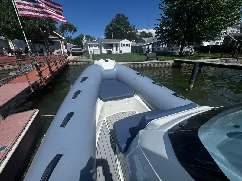Slide: The Image of 2022 Brig Eagle 6 boat docked by lakeside homes, American flag waving. - 10