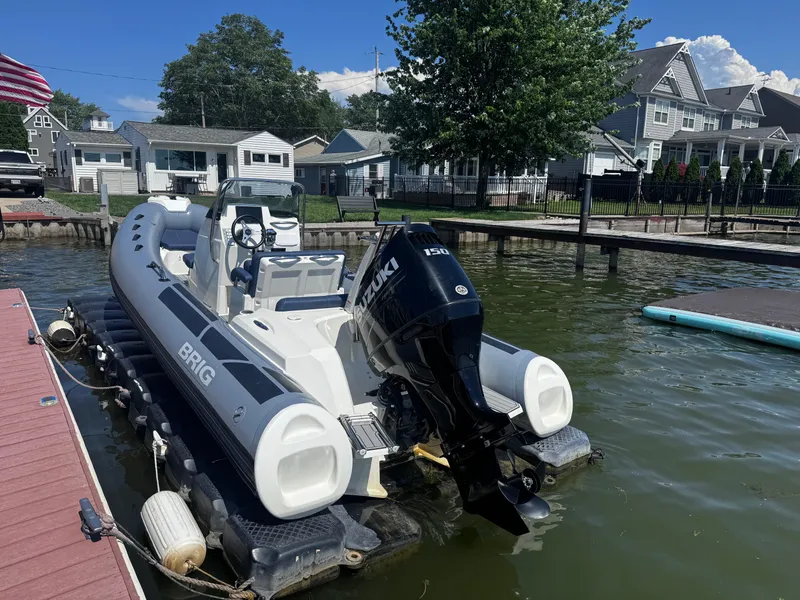 Slide: The Image of 2022 Brig Eagle 6 boat docked on a sunny day, featuring a Suzuki outboard motor. - 2