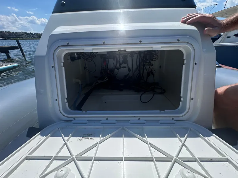 Slide: The Image of Open storage compartment on a 2022 Brig Eagle 6 boat, showing internal wiring. - 12