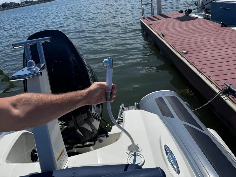 Slide: The Image of Man holding hose on 2022 Brig Eagle 6 boat near dock. - 26