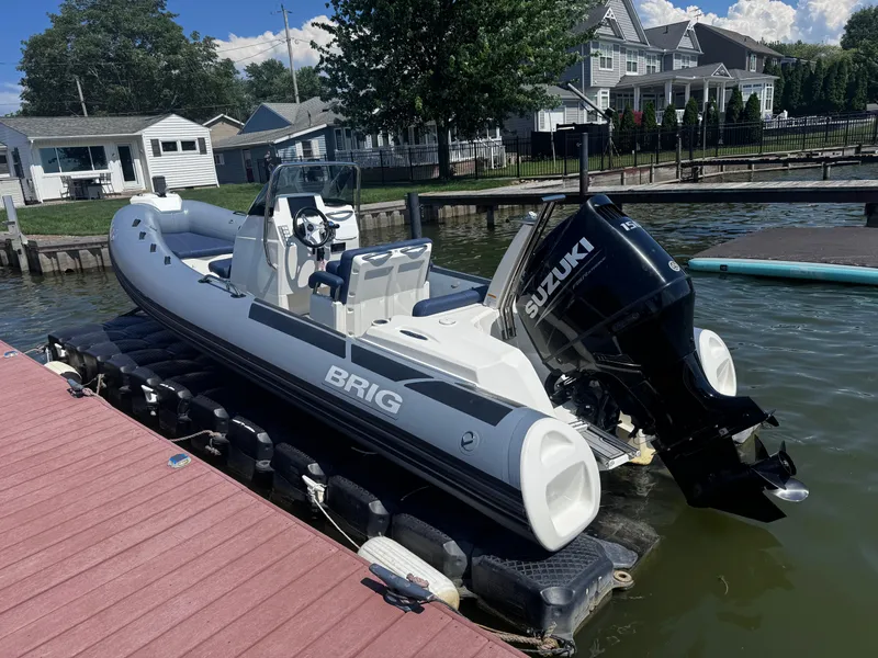Slide: The Image of 2022 Brig Eagle 6 boat with Suzuki engine docked by waterfront homes. - 3