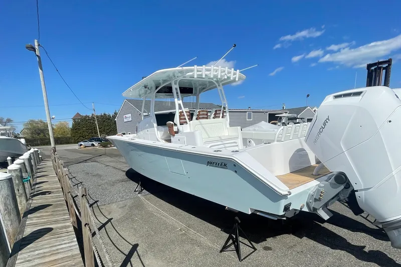 Slide: The Image of 2023 Jupiter 40 boat with Mercury outboard engine docked on a sunny day. - 1