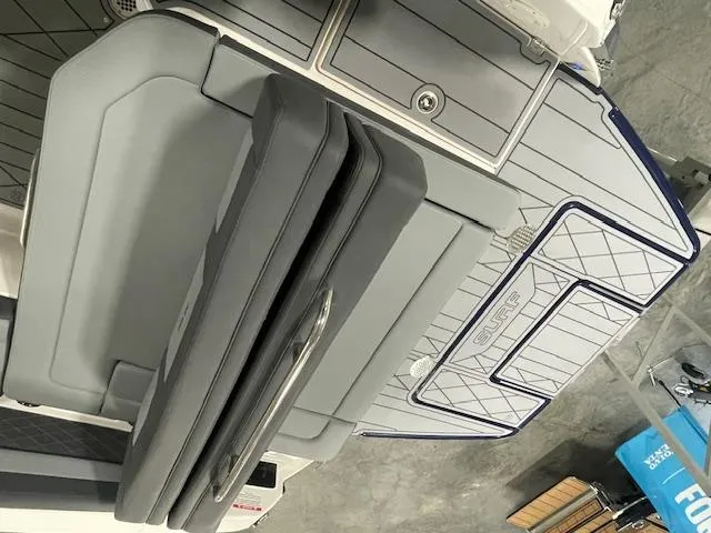 Slide: The Image of 2025 Chaparral 26 Surf boat interior with gray seating and deck details. - 12