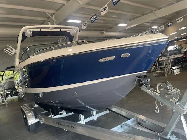 Slide: The Image of 2025 Chaparral 26 Surf boat on trailer in showroom. - 4