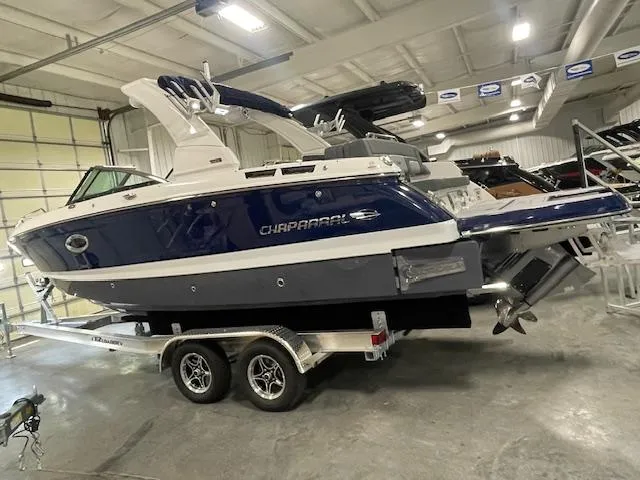 Slide: The Image of 2025 Chaparral 26 Surf boat on trailer in indoor showroom. - 5