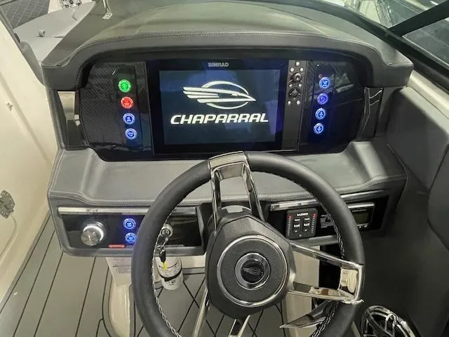 Slide: The Image of 2025 Chaparral 26 Surf dashboard with steering wheel and digital display. - 9