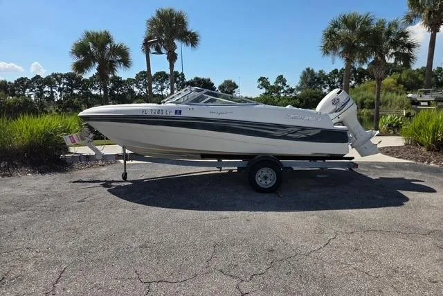 The Image of 2001 Four Winns 180 Horizon boat on trailer, parked outdoors with palm trees in background. - 0