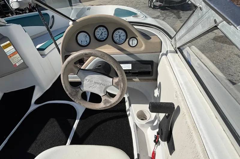 Slide: The Image of Interior view of a 2001 Four Winns 180 Horizon boat dashboard and steering wheel. - 5