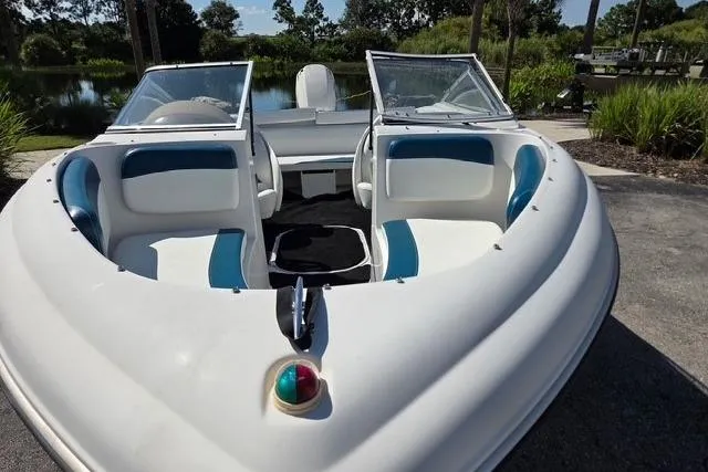 Slide: The Image of 2001 Four Winns 180 Horizon boat with open bow seating, parked near a scenic lake. - 4