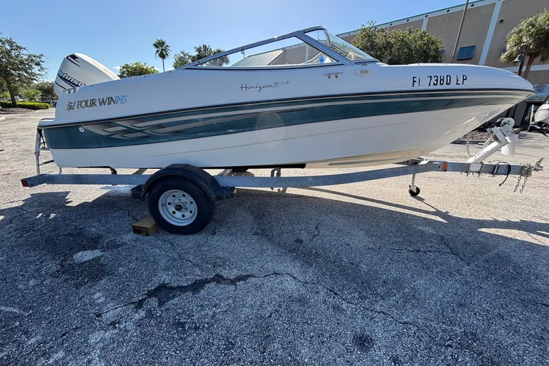 Slide: The Image of 2001 Four Winns 180 Horizon boat on trailer, parked outdoors. - 2