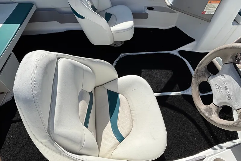 Slide: The Image of Interior of a 2001 Four Winns 180 Horizon boat with white and teal seating. - 7