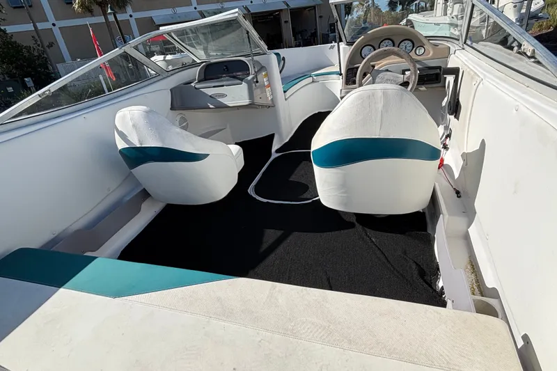 Slide: The Image of Interior of a 2001 Four Winns 180 Horizon boat with white and teal seating. - 4