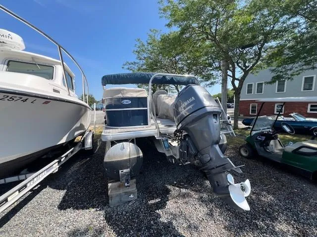 Slide: The Image of 2016 Godfrey 242 Premiere pontoon boat with Yamaha outboard motor, parked on gravel. - 12