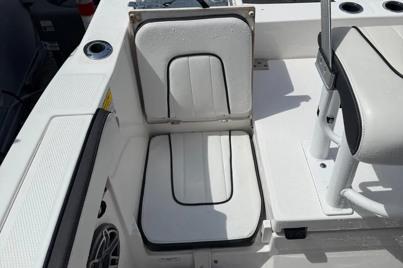 Slide: The Image of 2023 Yamaha Boats 222 FSH Sport interior seating with white cushioned seats and cup holders. - 10