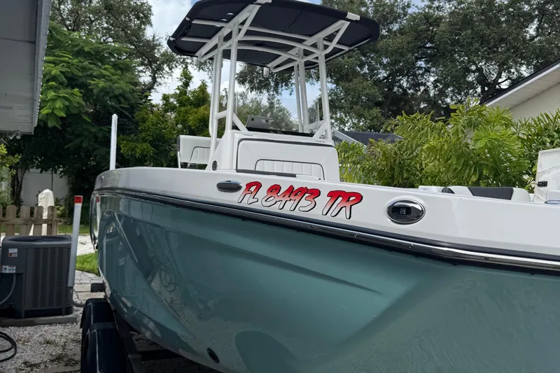 Slide: The Image of 2023 Yamaha Boats 222 FSH Sport in a driveway, surrounded by greenery. - 12