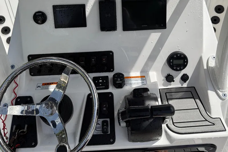 Slide: The Image of Control panel of 2023 Yamaha Boats 222 FSH Sport, featuring steering wheel and navigation instruments. - 15