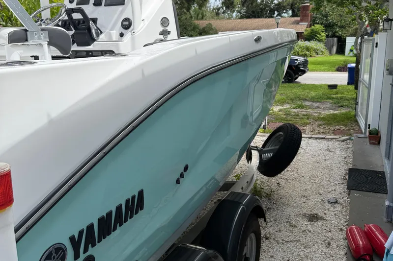 Slide: The Image of 2023 Yamaha Boats 222 FSH Sport in driveway, side view, light blue hull. - 16