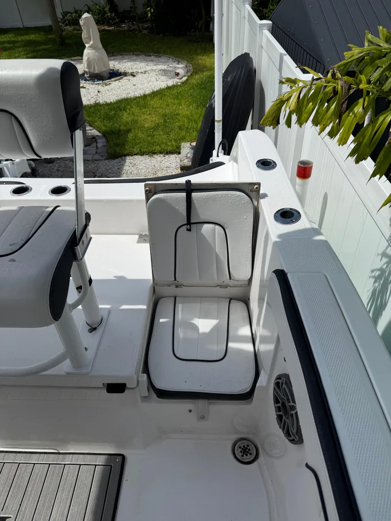 Slide: The Image of 2023 Yamaha Boats 222 FSH Sport interior with seating and storage, in a sunny outdoor setting. - 5