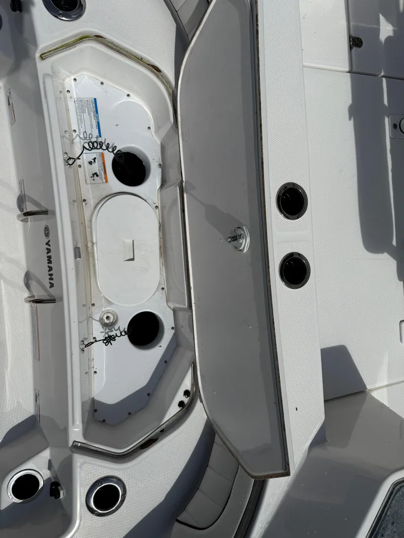 Slide: The Image of 2023 Yamaha Boats 222 FSH Sport interior, featuring storage compartments and cup holders. - 6