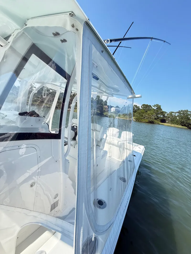 Slide: The Image of 2018 Sea Hunt Gamefish 30 boat with clear enclosure on calm water. - 17