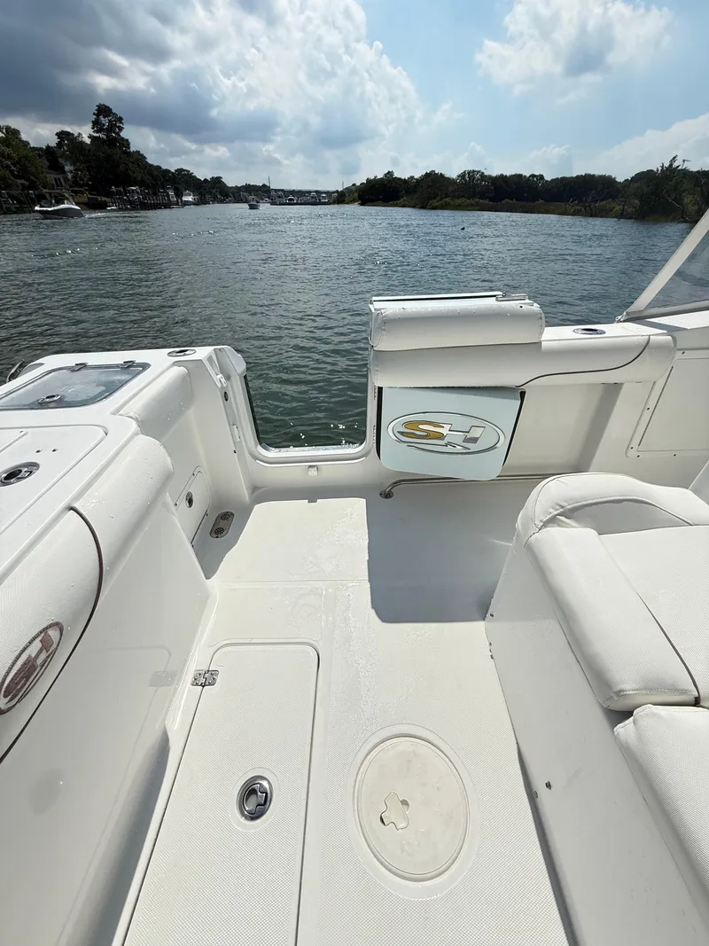 Slide: The Image of 2018 Sea Hunt Gamefish 30 boat interior with forward seating, overlooking a scenic waterway. - 19