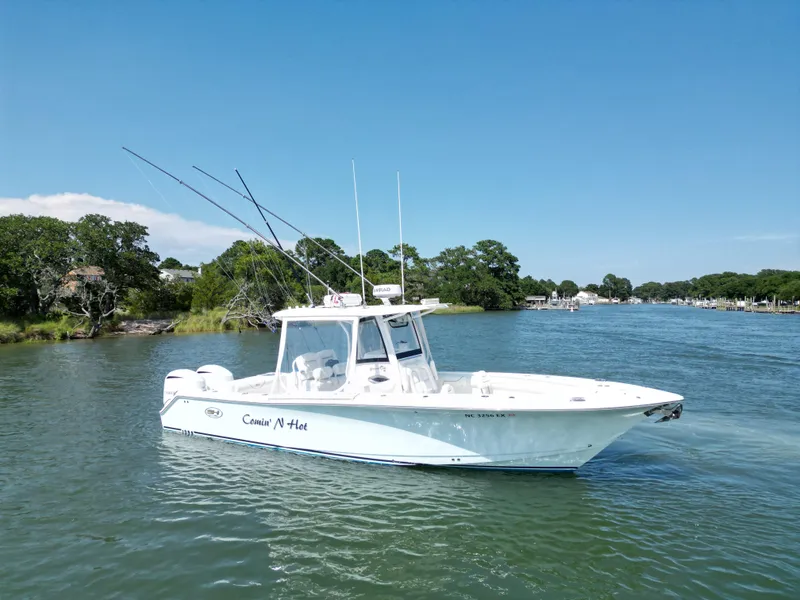 Slide: The Image of 2018 Sea Hunt Gamefish 30 boat on a scenic river with lush greenery. - 2
