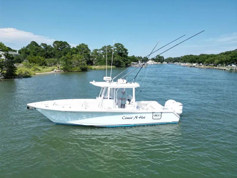 Slide: The Image of 2018 Sea Hunt Gamefish 30 boat on a serene river with lush greenery. - 3