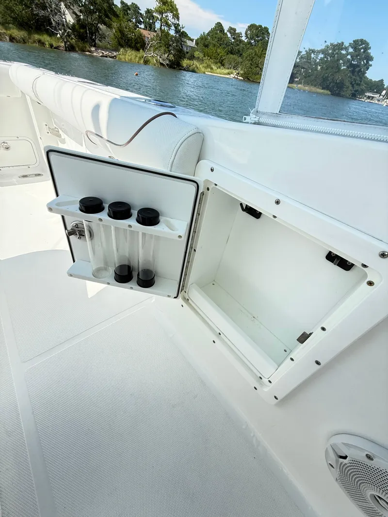 Slide: The Image of 2018 Sea Hunt Gamefish 30 boat storage compartment with rod holders, near scenic waterway. - 32